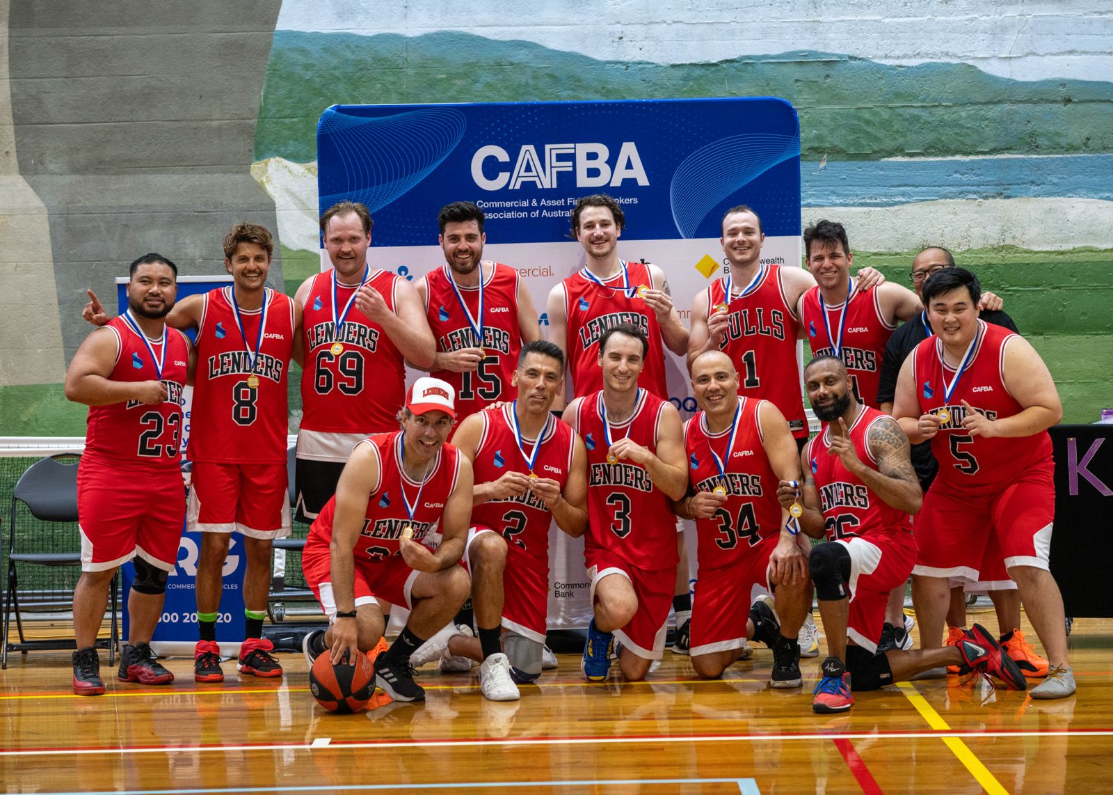 The Year 1 Lenders squad in red jerseys showing off their medals