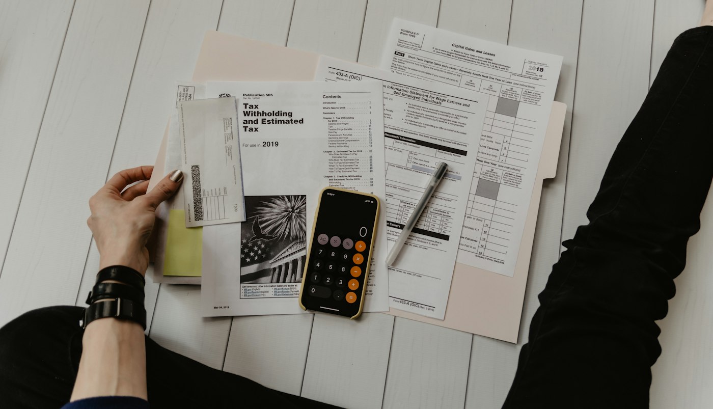 Business owner reviewing tax paperwork with a calculator