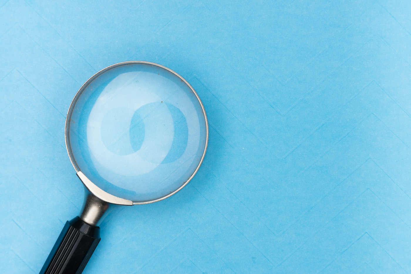 Magnifying glass on a desk, checking the fine print