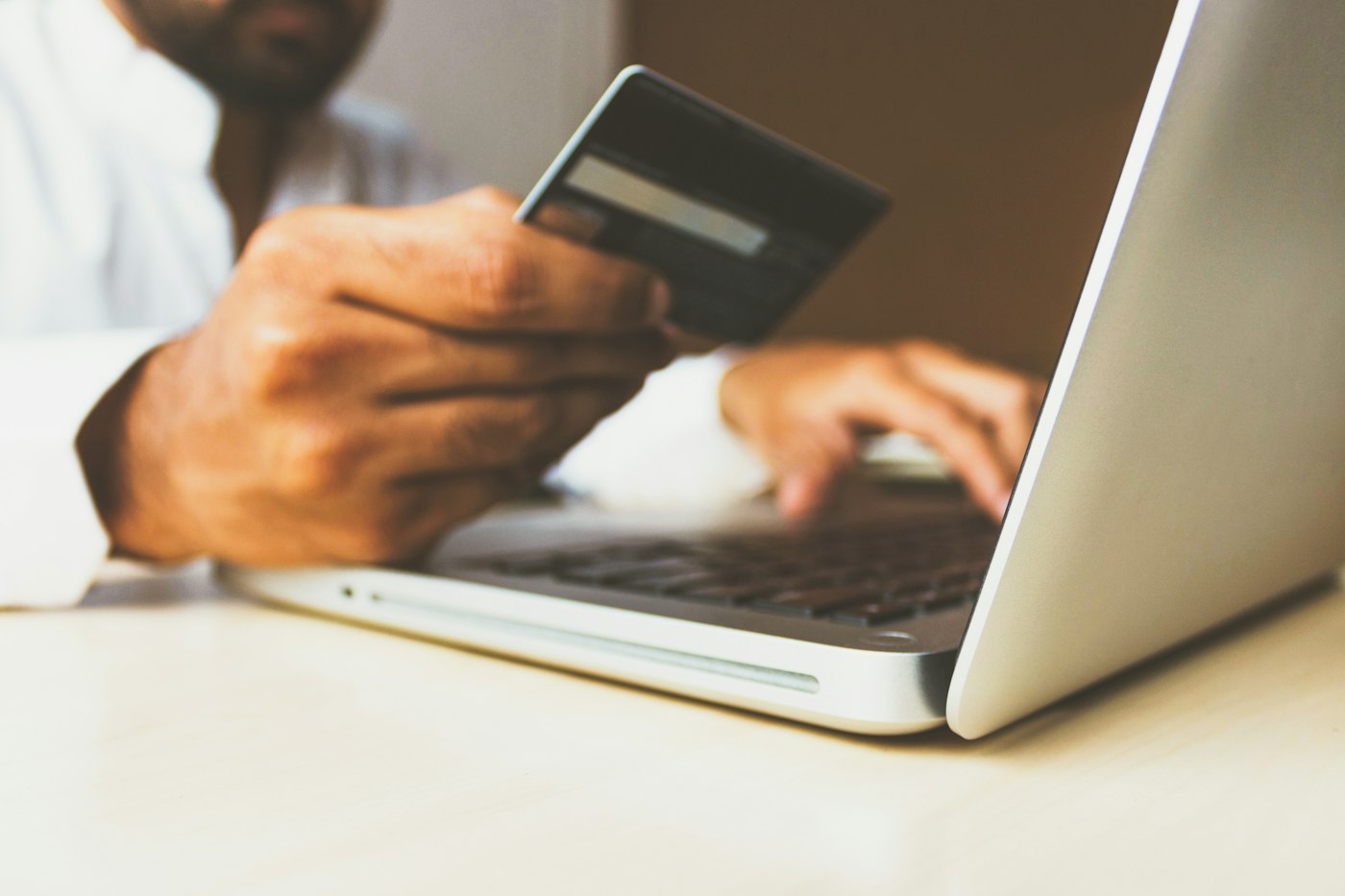 Person using a laptop while holding a card