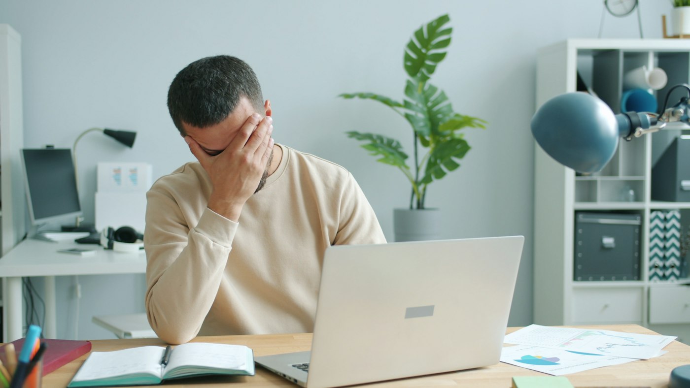 Business owner worried about loan repayments at his laptop
